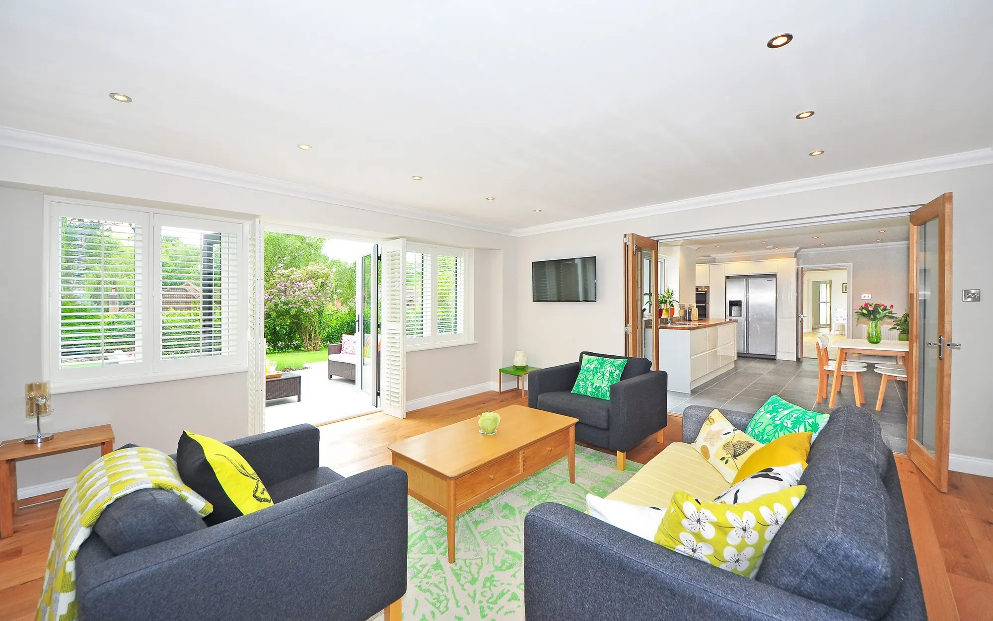 Stock photo of a bright, tidy living room with yellow and green cushions