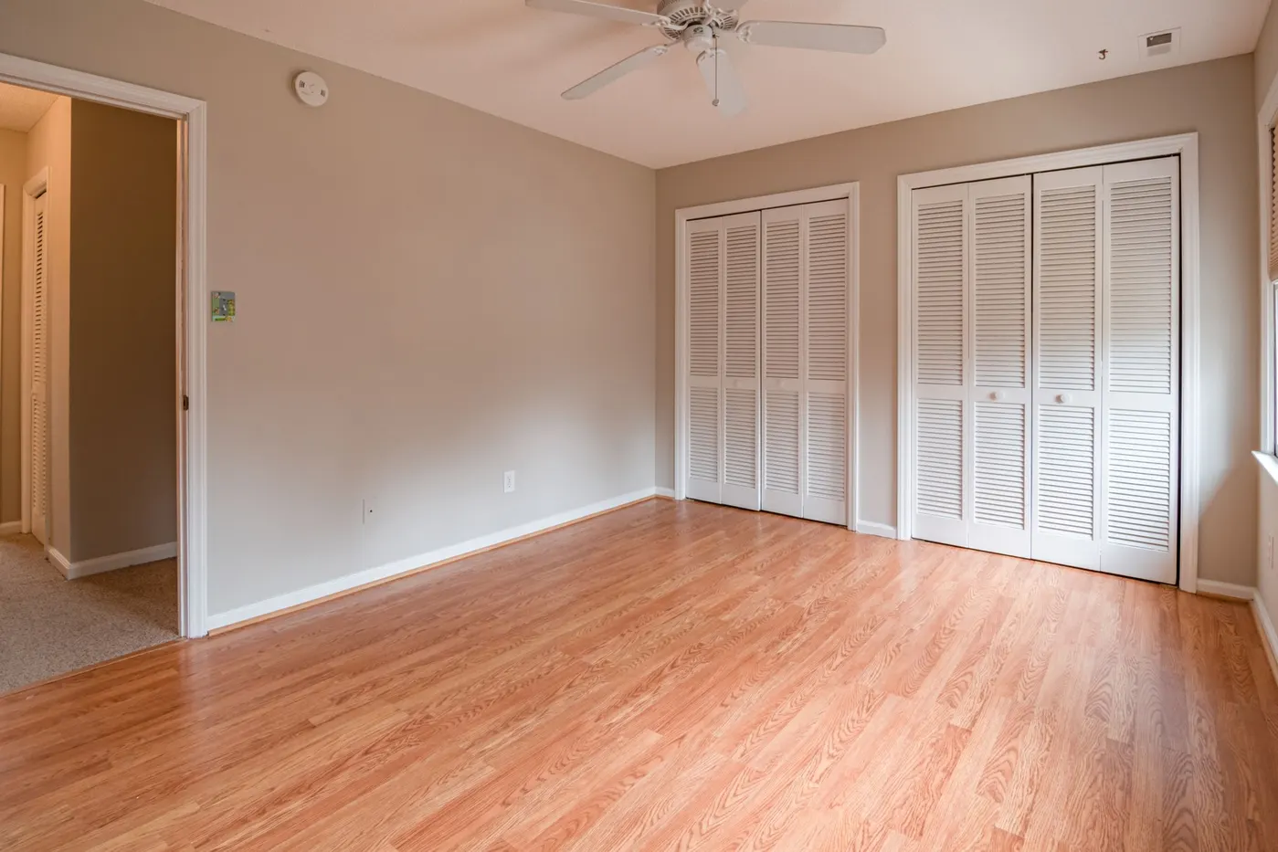 Stock photo of an empty room with wood floors and closet doors
